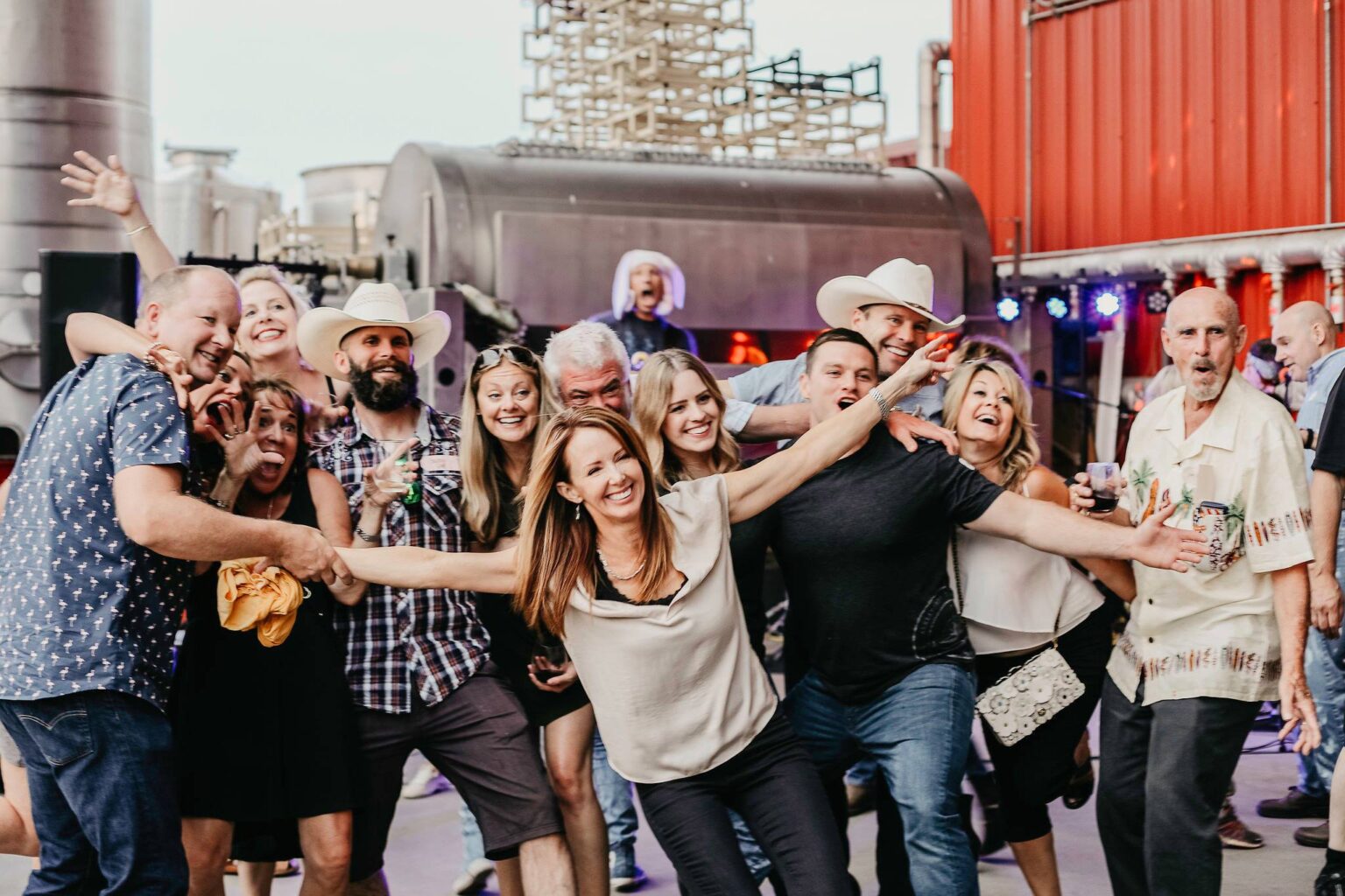 Excited group of friends celebrating at outdoor concert event