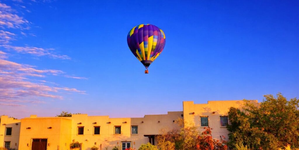 Colorful hot air balloon floating over Southwest adobe buildings