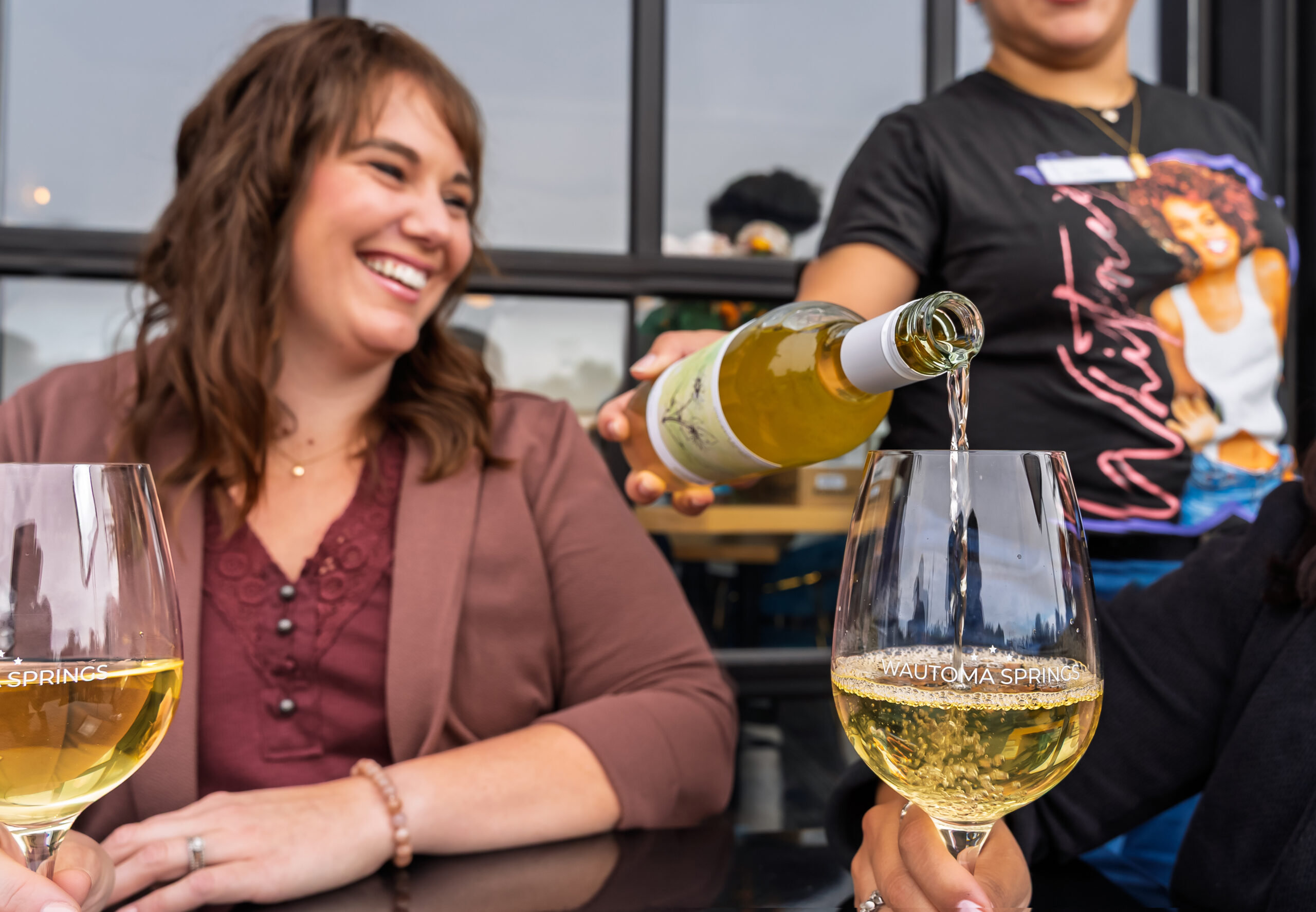 Woman smiling as white wine is poured at Wautoma Springs