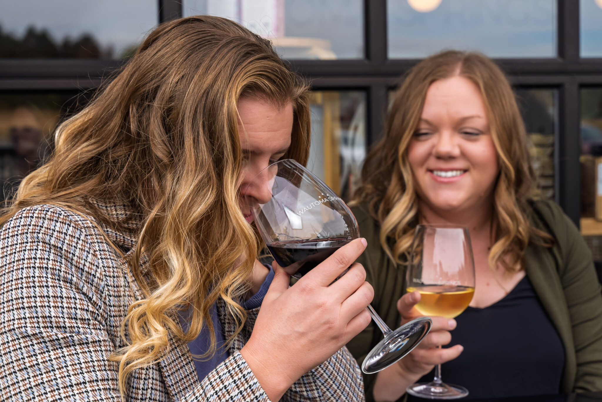 Two women enjoying wine tasting at a winery