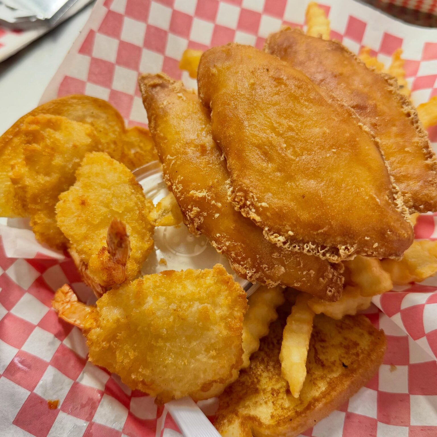 Fried fish sandwich with shrimp and fries in basket