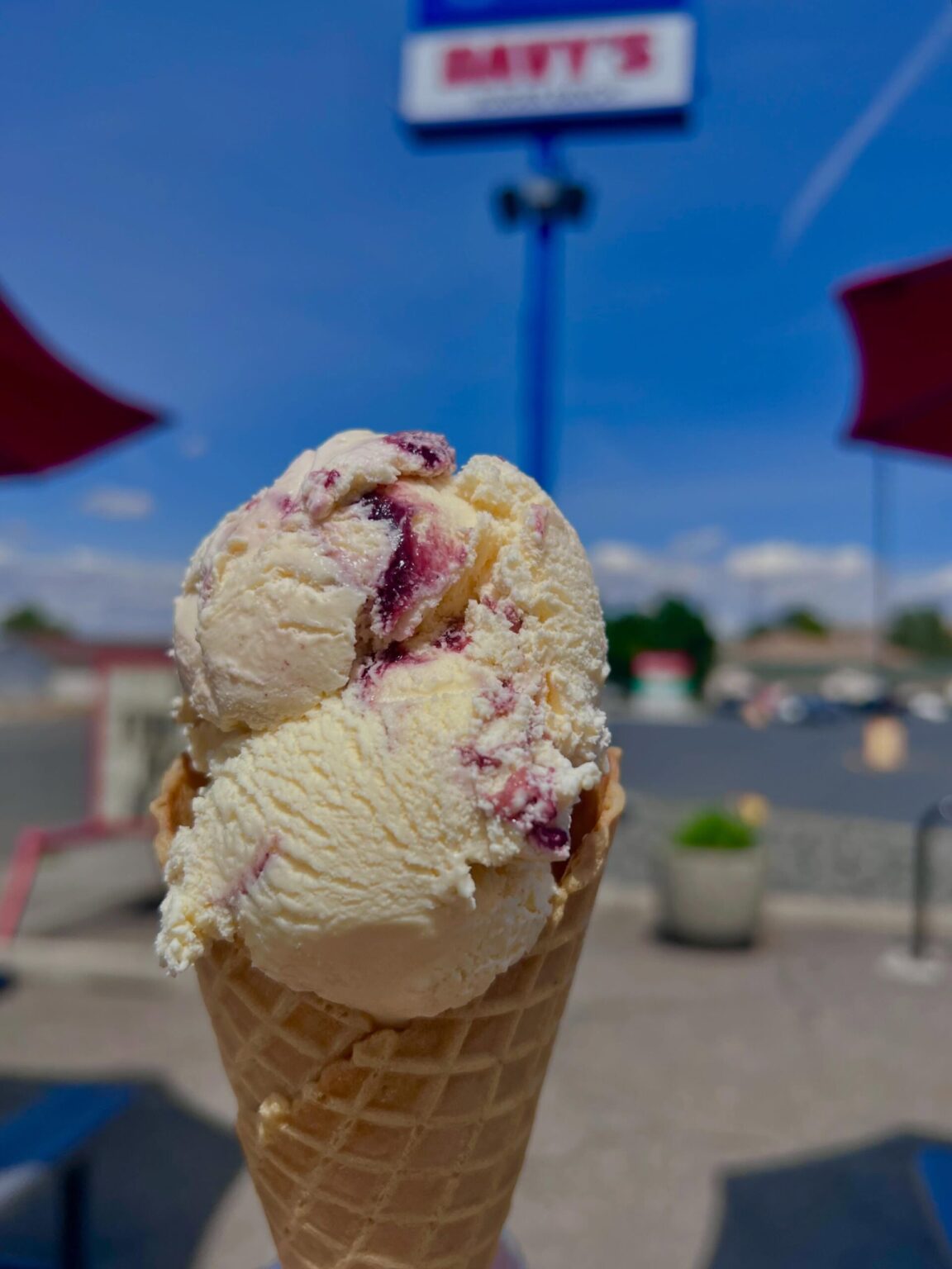 Double scoop raspberry swirl ice cream waffle cone outdoors