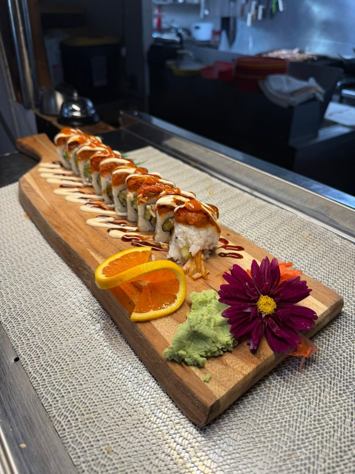 Elegant sushi roll platter on wooden board with garnishes